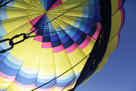 low angle photography of multicolored hot air balloon under clear blue sky thumbnail