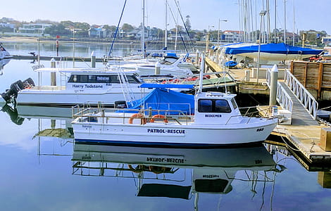 White Patrol-rescue Boat Near Brown Wooden Sea Dock thumbnail