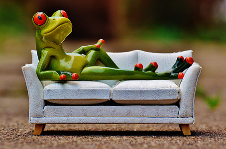green tree frog lounging on white sofa figurine thumbnail
