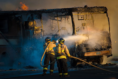 two firefighters dousing fire on bus thumbnail
