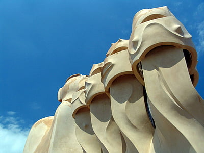 selective focus photo of brown concrete statue under white clouds and blue sky thumbnail