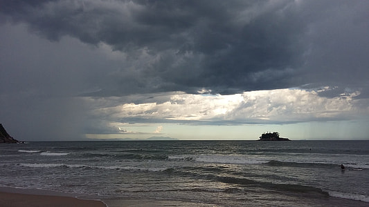 body of water and shore covered by clouds thumbnail