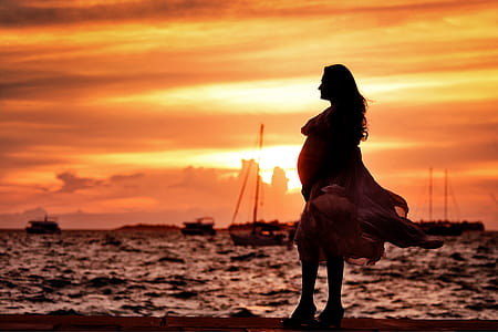 Pregnant Woman Standing Near Seashore during Sunset thumbnail