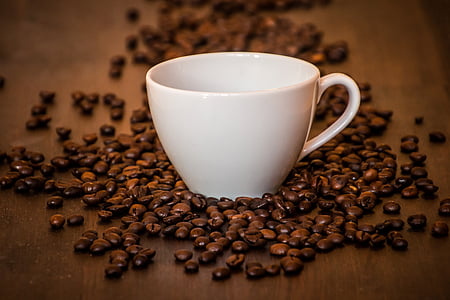 white ceramic cup surrounded of coffee beans thumbnail