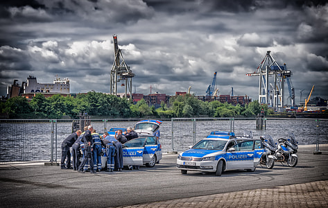 policemen leaning on police car hood on the street thumbnail