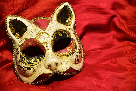 gold masquerade cat mask on red textile thumbnail