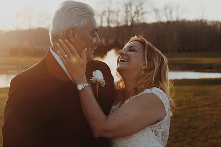 couple in suit and wedding dress on a green field looking at each other thumbnail