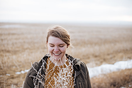 woman holding plant while smiling thumbnail