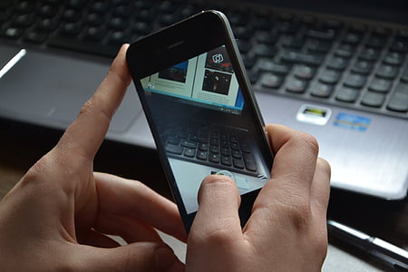 person holding black iPhone 4 thumbnail