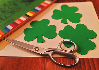 silver scissors beside green clover paper cutouts thumbnail