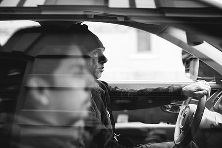 grayscale photo of man driving thumbnail