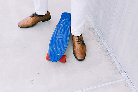 man in brown dressed shoes near the penny board thumbnail
