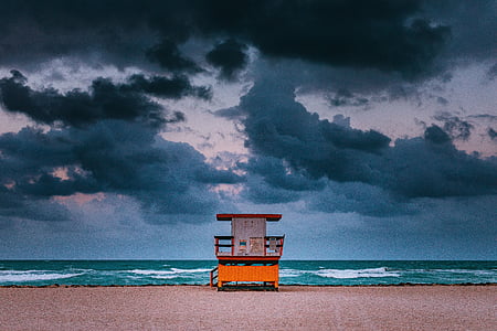 white and brown lifeguard house on seashore during daytime thumbnail