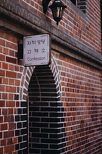 white Confession signage on brown bricks thumbnail
