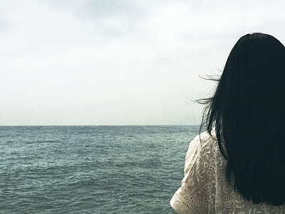woman in white shirt facing ocean thumbnail