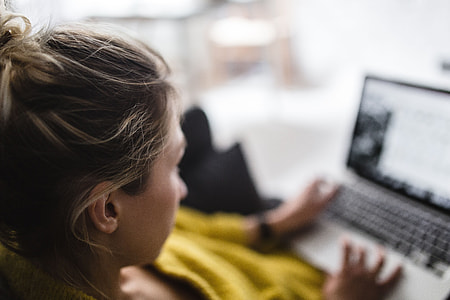 Young woman sitting on the sofa and working on her laptop thumbnail