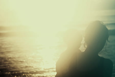 woman carrying baby while facing body of water thumbnail