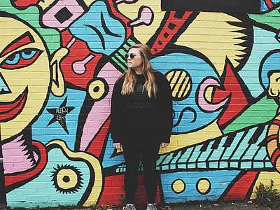 woman wearing black shirt leaning back on graffiti wall thumbnail