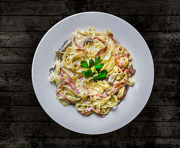pasta on round plate on brown wooden table thumbnail