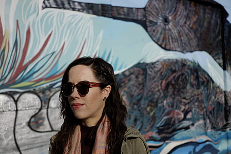 woman wearing black sunglasses beside the mural painting thumbnail