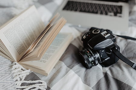 A camera, MacBook, and a book waiting in bed thumbnail