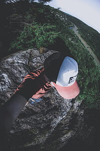 man standing on cliff taking selfie thumbnail