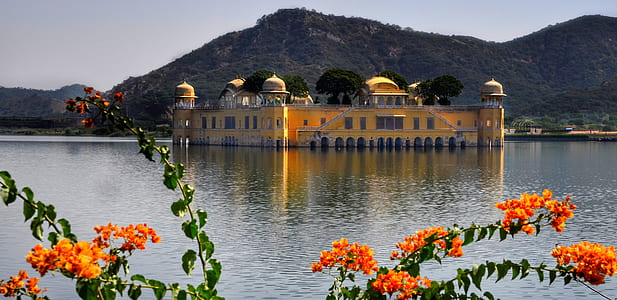 building on body of water near mountains thumbnail