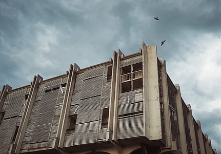 beige concrete building under cloudy sky thumbnail