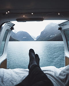 person facing towards body of water and mountain thumbnail