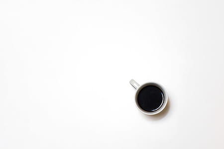 top view photo of white ceramic mug with tea on white surface thumbnail