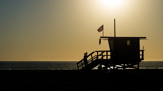 Silhouette of Life Guard House Near Ocean during Sunset thumbnail