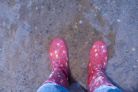 Person Wearing Pink Knee-high Rain Boots Standing on Brown Floor thumbnail