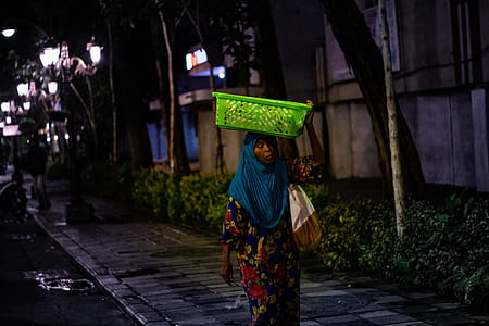Woman Carrying Green Basket On Her Head thumbnail