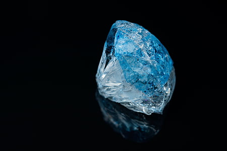 round blue gemstone with black background thumbnail