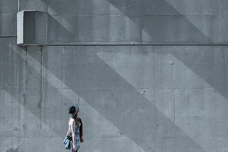 woman standing beside gray wall thumbnail