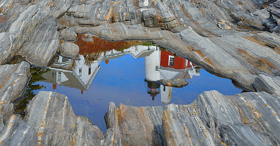 reflection of white lighthouse on body of water thumbnail