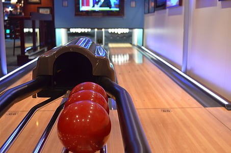 three red bowling balls on bowling alley thumbnail