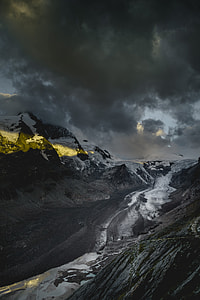 snow covered mountains under grey cloudy sky thumbnail