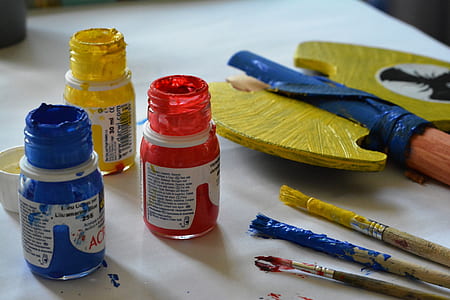 blue, yellow, and red paint containers on white table thumbnail