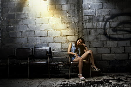 sitting woman on chair beside concrete wall thumbnail