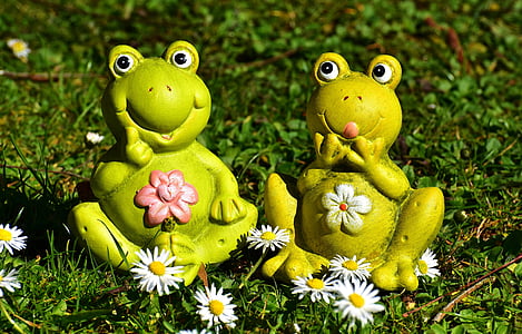 two green frog figurines beside white petaled flowers thumbnail