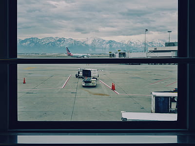 view of airplane and caddy on airport during daytime thumbnail