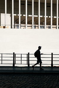 silhouette of a man walking using phone thumbnail