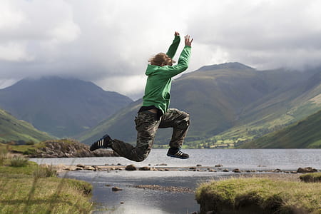 man in mid air near body of water thumbnail