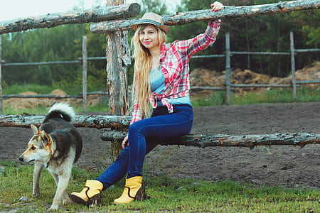 adult German shepherd beside woman sitting on wooden fence at daytime thumbnail