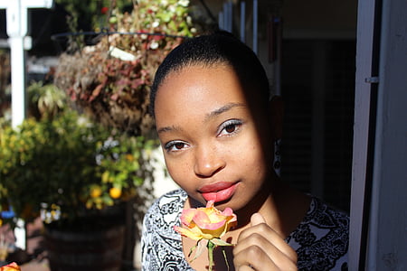 woman holding red and yellow petaled flower thumbnail