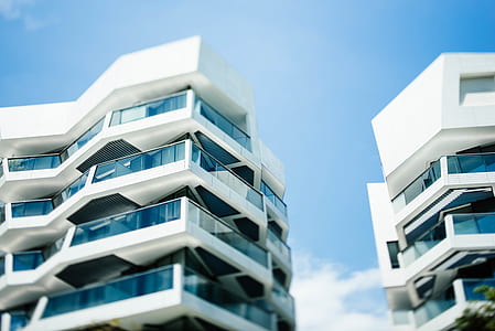 low angle photography of white concrete buildings thumbnail