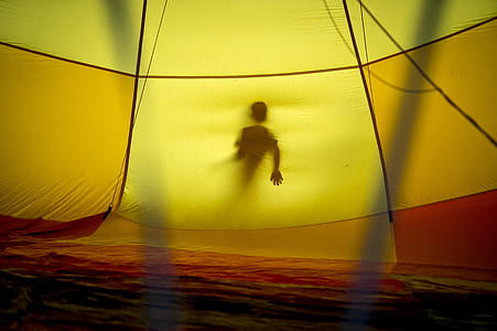 person behind yellow tent thumbnail