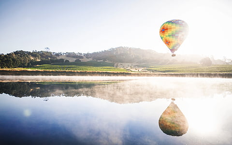 hot air balloon near rice field at daytime thumbnail