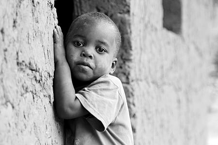 grayscale photo of toddler leaning beside concrete wall thumbnail